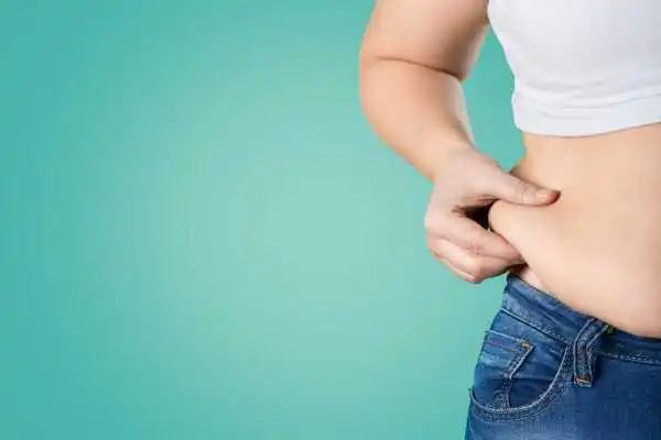 Image of woman pinching her love handles to show weight gain Leicestershire