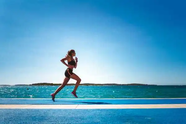 Woman running showing strong leg muscle Leicestershire